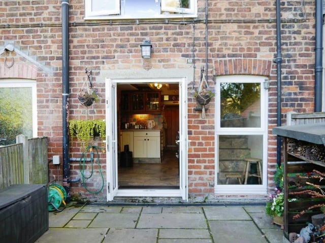 A view from the back of the cottage, with French doors leading out from the kitchen.