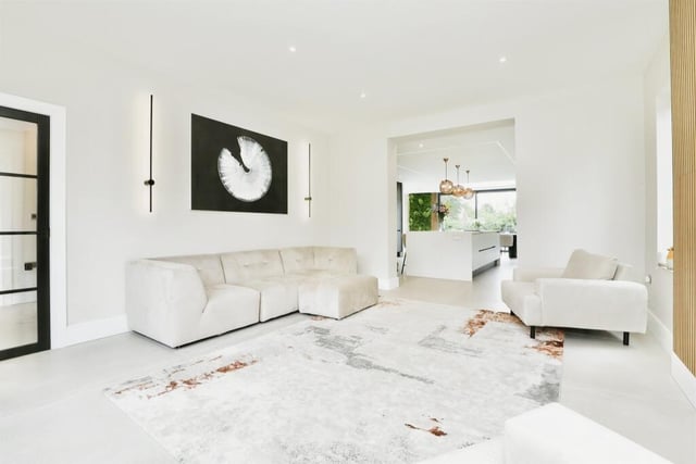 Off the kitchen is this lovely lounge or living room, which demonstrates how the property has been modernised and finished to a high specification. It is bright and comfortable, with two side-windows, either side of a focal-point media wall, and a front-facing window.