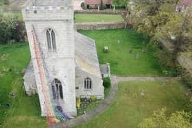 A rainbow floral cascade is flowing from All Saints church tower in Rampton