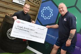 Graham White, commercial group director of Mark's main sponsors Carlton Forest Group, has his own go in the ice water and hands over a cheque for £500.
