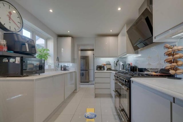 Next stop on our tour is this modern kitchen, which is fitted to the highest quality, complete with high-gloss wall and base units, granite work surfaces and a sink unit with mixer tap.