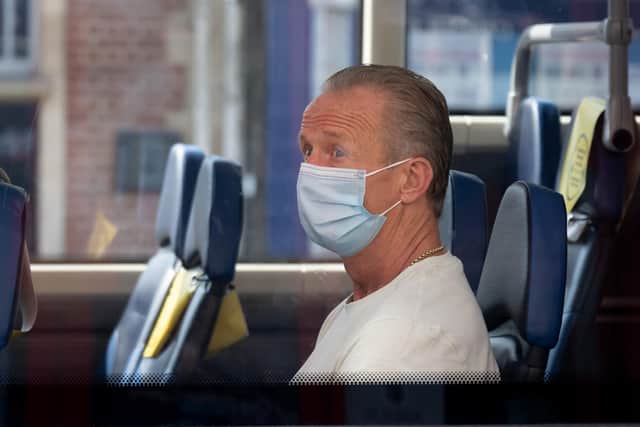A man wears a surgical face mask on a bus (Photo by Matthew Horwood/Getty Images)