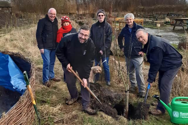 Volunteers plant the new 'Pilgrim 400' apple tree at the nature reserve in Retford.