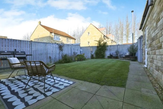 The serene back garden features pleasant patio areas, suitable for seating -- and relaxing!