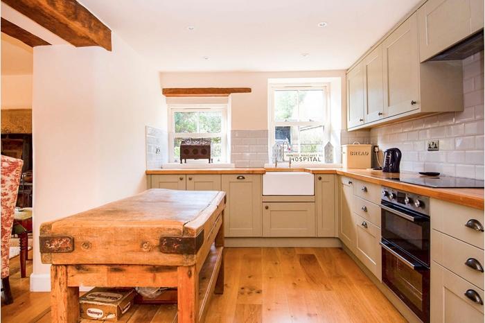 With a range of modern wall and base units. The units are complemented by wooden work surfaces which incorporate a Belfast-style sink. Integrated appliances include a slim-line dishwasher, a double oven and hob with extractor over.