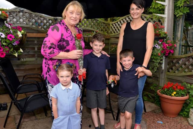 Guardian Rose presentation to Linda Silk, pictured receiving her rose from Louise Baxendale and children Harry, eight, Molly, three and George, five