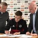 David Brooks, flanked by Chris Wilder (left) and head of football administration Shieber (right) signs a new contract with Sheffield United