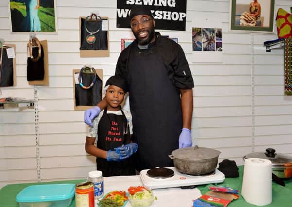 Eight-year-old Mikah Hylton-Mais helps his dad, Richard, at the event at the Westaf African Caribbean shop.