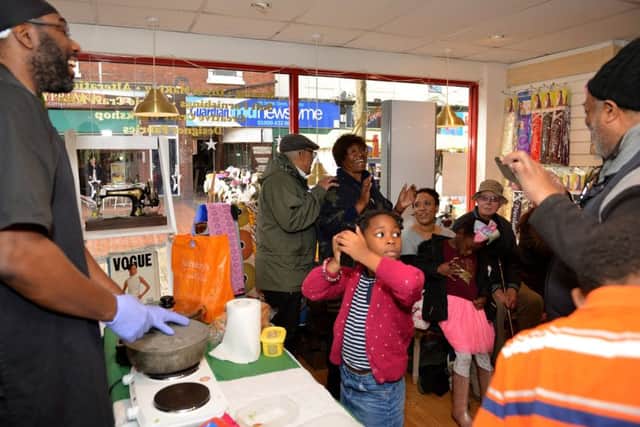 Visitors enjoy the cooking demonstration at the Westaf African Caribbean shop.