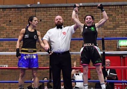 The referee raises the arm of Xbox Academy captain Nicola Hopewell to signal her victory.
