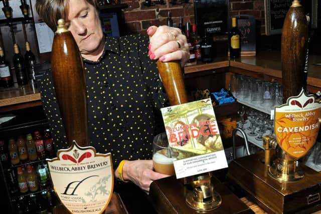 Bev Copestake, the manager at the Forest Lodge Hotel in Edwinstowe, pulls a pint of the Clumber Park Bridge.