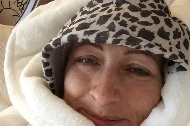 In bed, surrounded by scarves and fluffy fleeces, Sue recovering from chemotherapy.