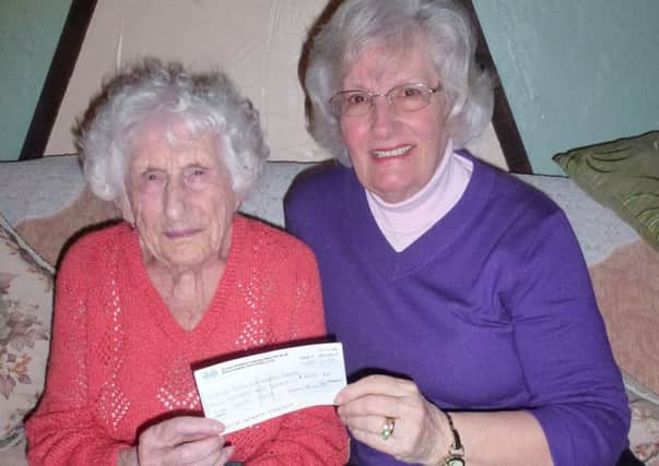 Wendy King from Bluebell Woods Retford Support Group collects the donation from Mrs Clayton.