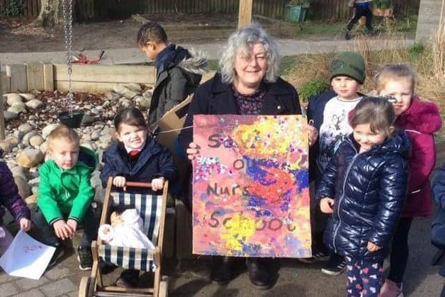 Jo Noble with the children at Gainsborough Nursery School with the placard they designed for her