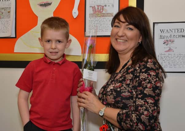 Guardian Rose presentation to Redlands Primary School teaching assistant Liane Tuke from pupil Ethan Myers, six