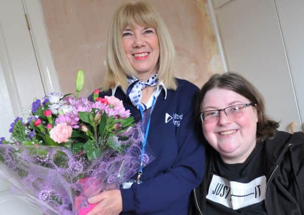 Lifesaver Vanessa Welch is presented with a bouquet of flowers by grateful tenant Amanda Sheehan (right).