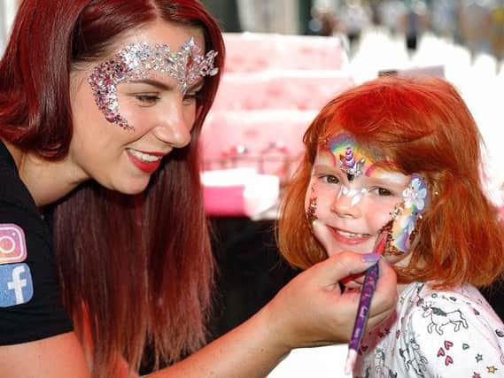 Five-year-old Phoebe Stephenson gets her face painted by Kether Barnett, proprietor of Cloud 9 Faces
