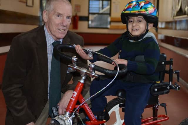 Ray Matthews presents a modified trike to Newman School pupil Junayd Boston