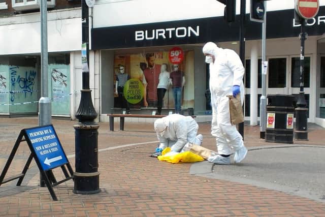 Forensic officers work at the scene where a 40-year-old man died on Saturday night