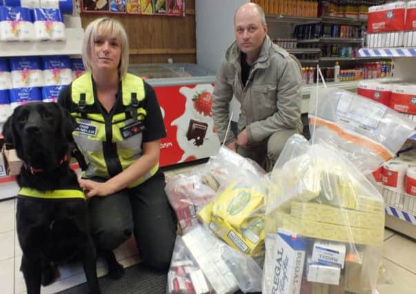 Louise Wilson from Wagtail International Specialist Dog Services, a sniffer dog and Matt Rawson from Notts County Councils trading standards with the seizure of illicit tobacco products from one of the shops