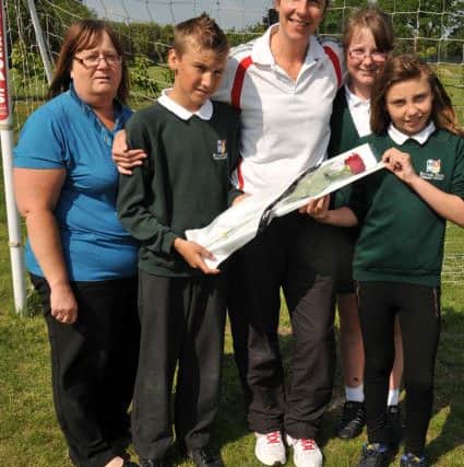 Guardian Rose presentation to PE teacher Mary Paton, pictured with Mary are members of the school's football teams and Cheryl Fox (w130607-1b)