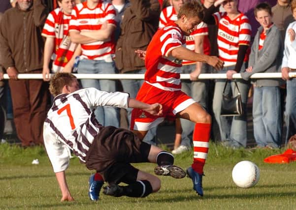 Doncaster Rovers' Craig Nelthorpe on the attack against Retford United's Lee Holmes. (Picture: CHRIS BULL D5095CB)