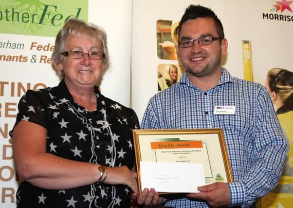 Wendy Wood of Kiveton Bungalow Users Group (KBUG) receives a gold award at the Rother Fed Quality Awards from Andy Boulton from South Yorkshire Housing