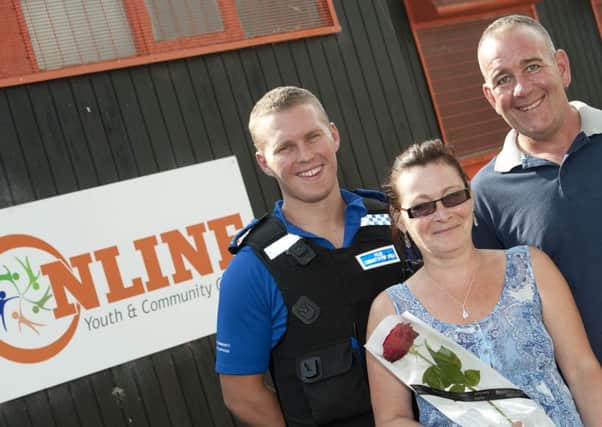Police Community Support Officer Ryan Bowskill presented the Guardian Rose to community centre volunteers Carolyn and Glenn Gillgrass