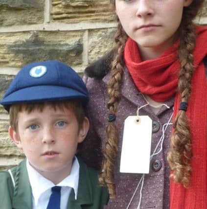 Evacuees Carrie (Juliet Ibberson) and her brother Nick (Thomas Ferris) anxiously wait to see if someone will give them a home