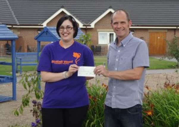 David Corbett, Race Director for Sherwood Pines Trail Races presenting a cheque for £540 to Emma Vizor of Bluebell Wood Childrens Hospice on behalf of Retford Athletic Club. In total the event, which was held on Sunday 21 July at Sherwood Pines Forest Park,  raised well over £1,000 for the hospice.