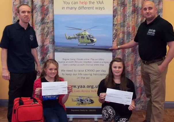 Jade Anderton and Abygayle Wood prerent cheques to the Five Villages First responders and Yorkshire Air Ambulance
