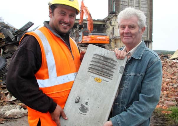 Demolition team leader Mick Dennington presenting former miner George Smith with the door of the locker he was allocated