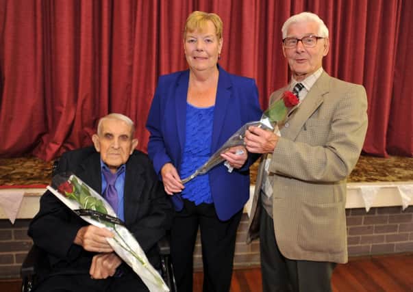 Eric Hitchman and Stuart Andrew receive their Guardian Roses from Oldcotes Village Hall chairman Margaret Smith