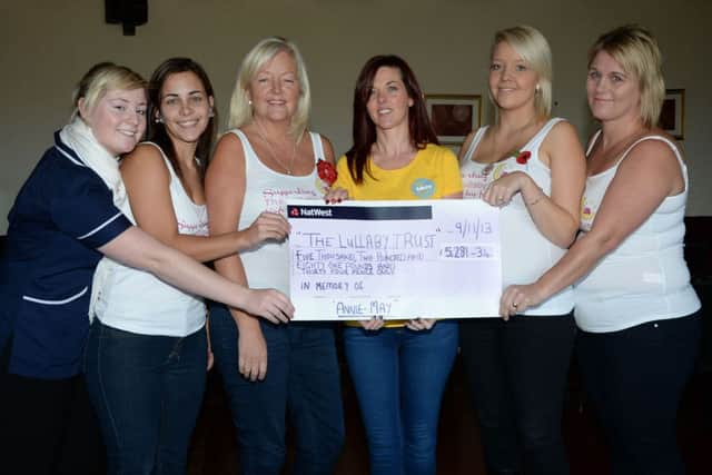 Amy Dennington and friends present a cheque for £5281.34p to the Lullaby Trust G131111-4a