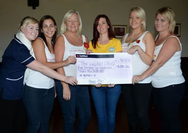 Amy Dennington and friends present a cheque for £5281.34p to the Lullaby Trust G131111-4a