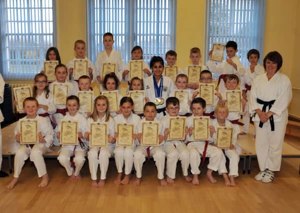 Children at Langold Dyscarr School proudly display their certificates after recieving their Karate red belts, pictured with Karate tutors and European champion Henna Shah (w131128-1a)