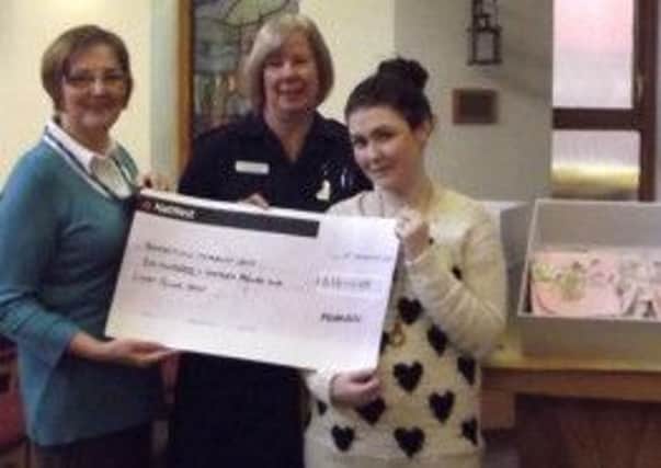 Ashley Baxendale (right) presents the cheque to Carol Lee and  Karen Cousins