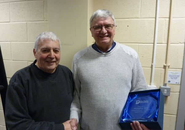 Alex McLauchlan, left, presents Mike Conroy with a trophy to mark his 33 years service
