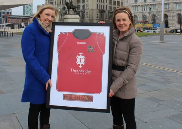 AdPlace Marketing's Amy Helliwell (left) presents the Sheffield FC shirt, signed by Chelsea star Gary Cahill, to Caring Matters Now chief executive, Jodi Whitehouse