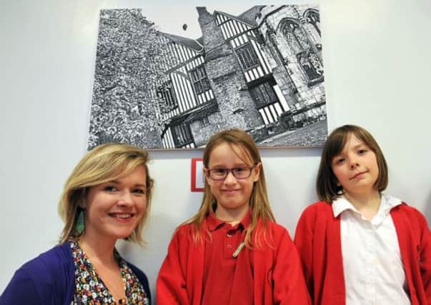 Children at Parish Church School have been working with photographer Charlotte Newton taking photographs of familiar sights from different viewpoints.  The school put on an exhibition of the children's work. Photographer Charlotte Newton is pictured with some of the pupils
(NGAS-14-02-14 RA 3e)
