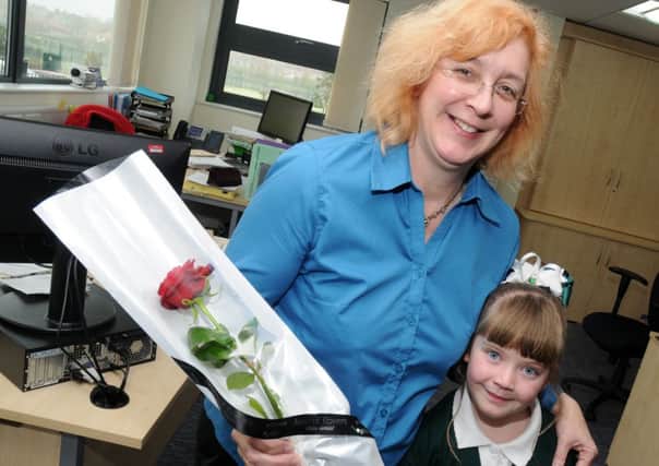 Tia Kirk presents Ryton Park Primary School assistant Kathryn Simes with a Guardian Rose
