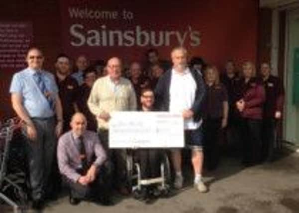 Paralympic wheelchair athlete Olli Taylor receives a funding cheque towards a new racing chair from Sainsbury's. Ollie works at the Worksop branch of the supermarket.