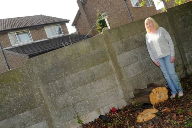 Julie Mciver next to the spot where the trees were hacked down