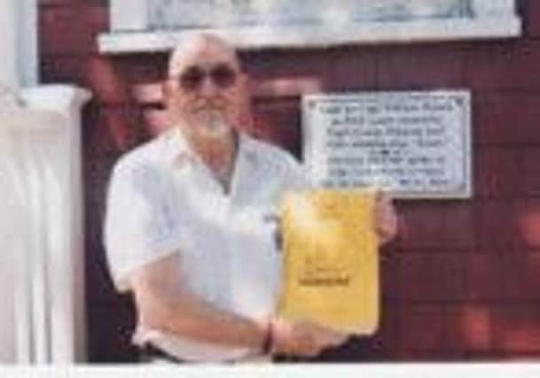 Pete Brammer outside Captain Pollard's house in Nantucket with a draft copy of his book about The Essex, the ship that inspired the novel Moby Dick