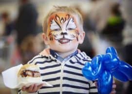 Fun day: A painted Fred enjoys a free sausage sandwich from the BBQ