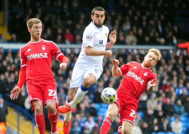 Giuseppe Bellusci goes past the challenge of Forest players Gary Gardner and Chris Burke.