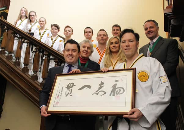 Master Andrew Blinston, from Lynx Blackbelt Leadership Academy, presents the rare Korean calligraphy scroll to Coun Simon Greaves, Bassetlaw Council leader