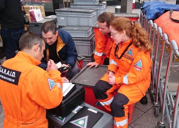 Volunteers from British charity Search and Rescue Assistance in Disasters (SARAID) check their equipment at Heathrow airport. Photo:PA