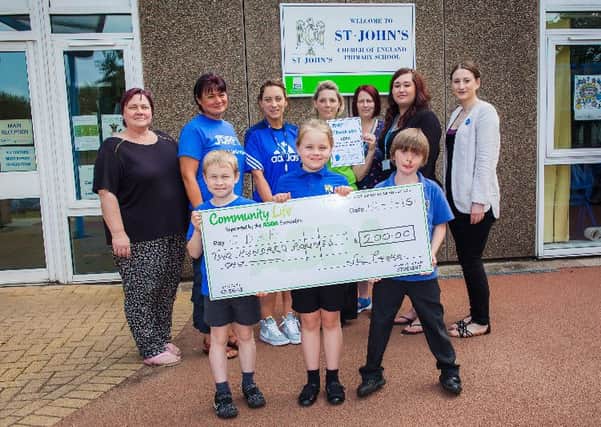 Nicola Peake, of Community Life at Asda Celtic Point, presents a cheque for £200 to St John's Primary Schoolin Worksop  to add to their fundraising account for Type 1 Diabetes charity JDRF. Also pictured are Sadie Munro (right) from JDRF North) school staff and Year Three pupils Andrew Ferrol, Chloe Hind and Dylan Peake. Picture: Rob Ferrol