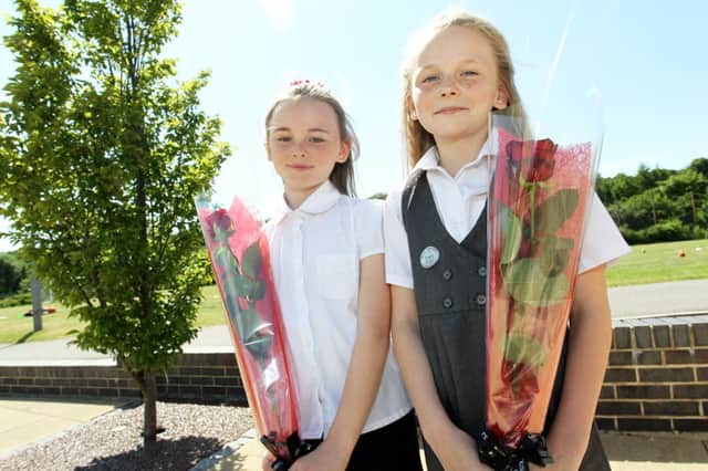 Sparken Hill Academy pupils Jessica Cooper, 11, and Amelia Cooper, 10, have been presented with a Guardian Rose because they are having their hair cut to donate to the Little Princess Trust.